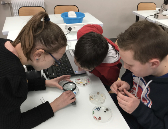 Trois élèves analysent des échantillons de plastique.